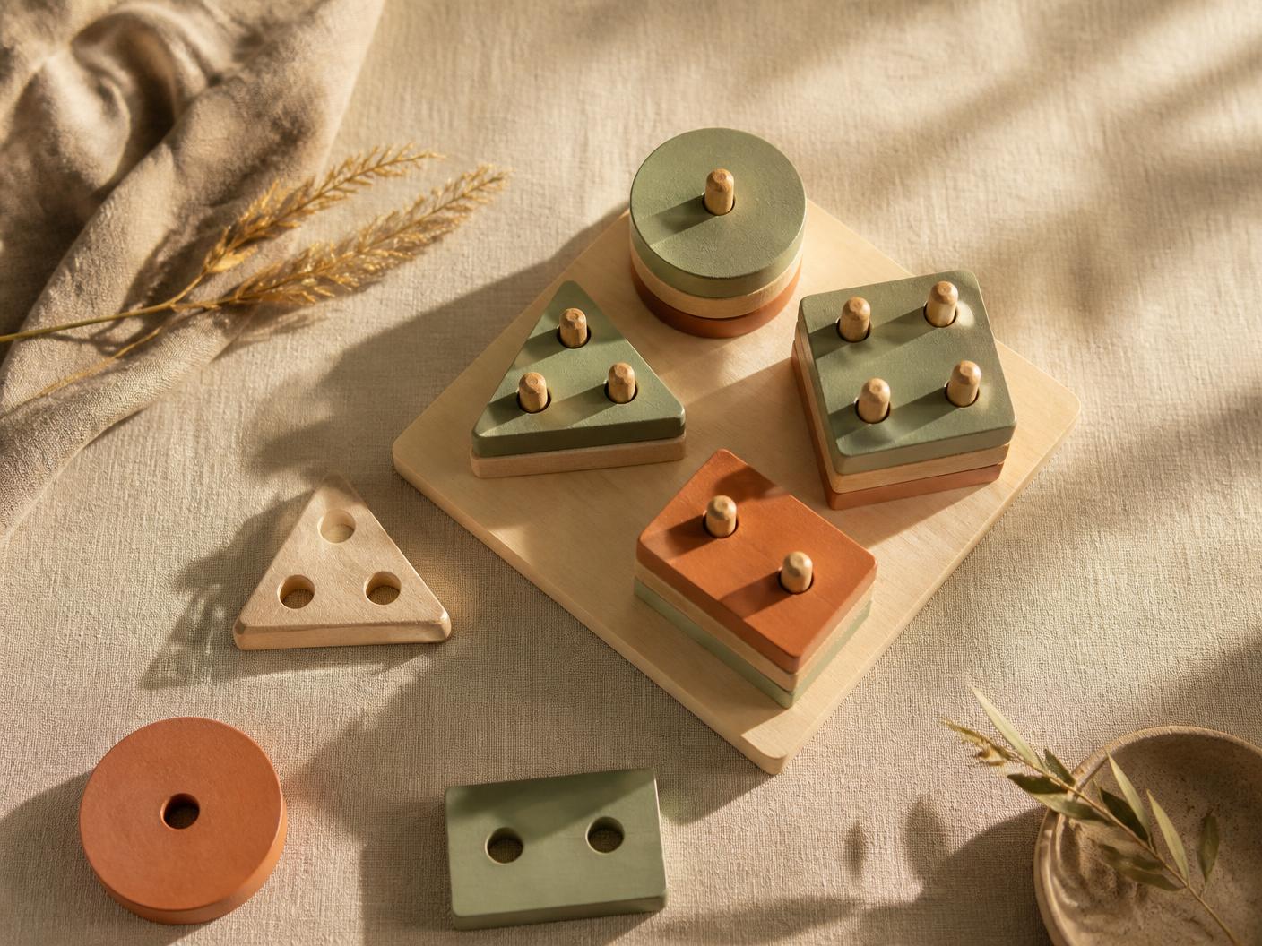 Wooden geometric stacking puzzles arranged on natural linen in warm afternoon light